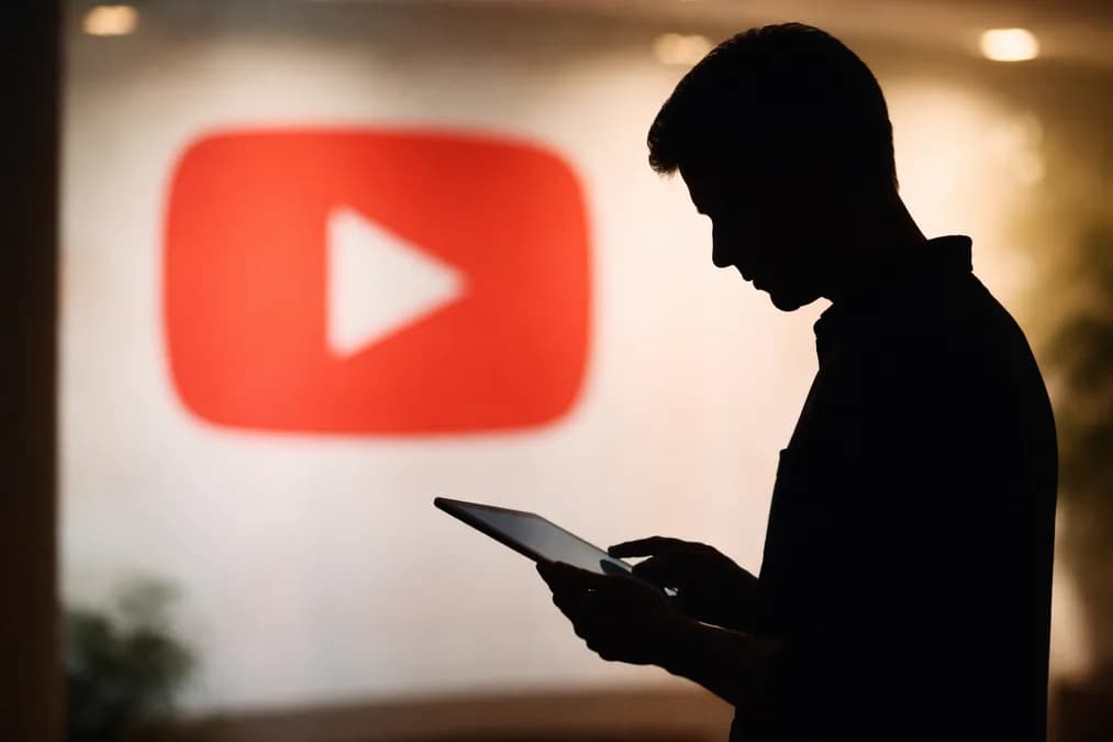 YouTube logo with silhouetted person: YouTube, TikTok, Snap Bayar $60 Juta untuk Program Kesehatan Mental Sekolah