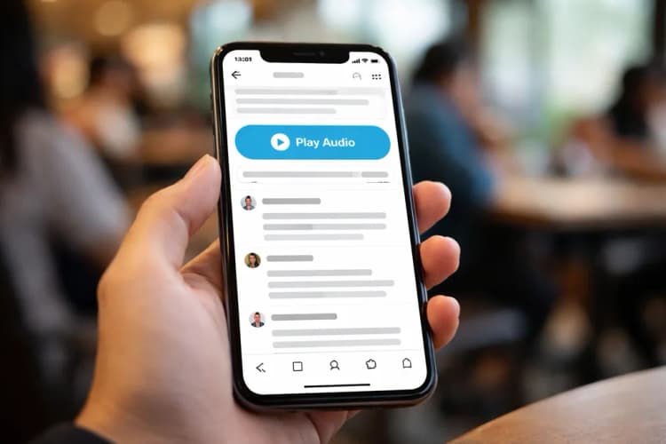 Ilustrasi layar ponsel menampilkan thread Reddit dalam bahasa Indonesia, dengan tombol 'Play Audio' berwarna biru di atas komentar pertama, dan garis waktu berjalan di bawahnya