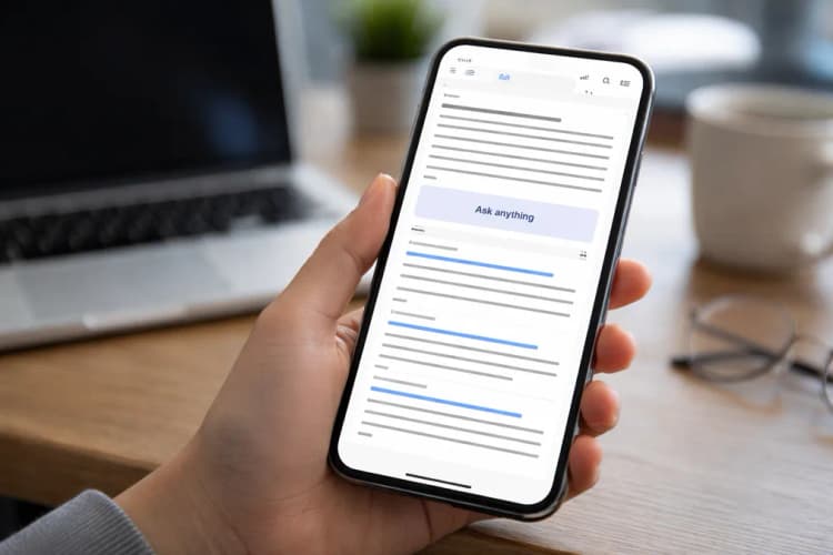 Ilustrasi layar ponsel menunjukkan hasil pencarian Google dengan ringkasan AI memenuhi sepertiga atas layar, kotak 'Ask anything' di tengah, dan daftar tautan baru muncul setelah gulir dua kali